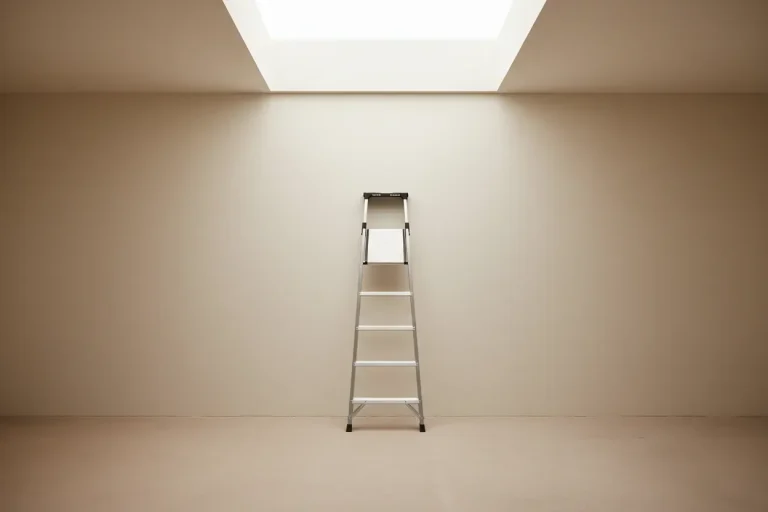 Minimalist ladder reaching toward a skylight in a soft neutral room, symbolizing professional growth.